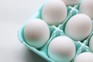 white eggs on teal egg tray